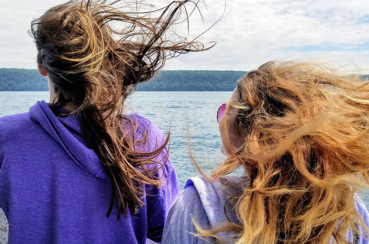 Enjoying a windy boat tour of Pictured Rocks National Lakeshore on Lake Superior in Munising, Michigan - Upper Peninsula - 2 women with wild windblown hair