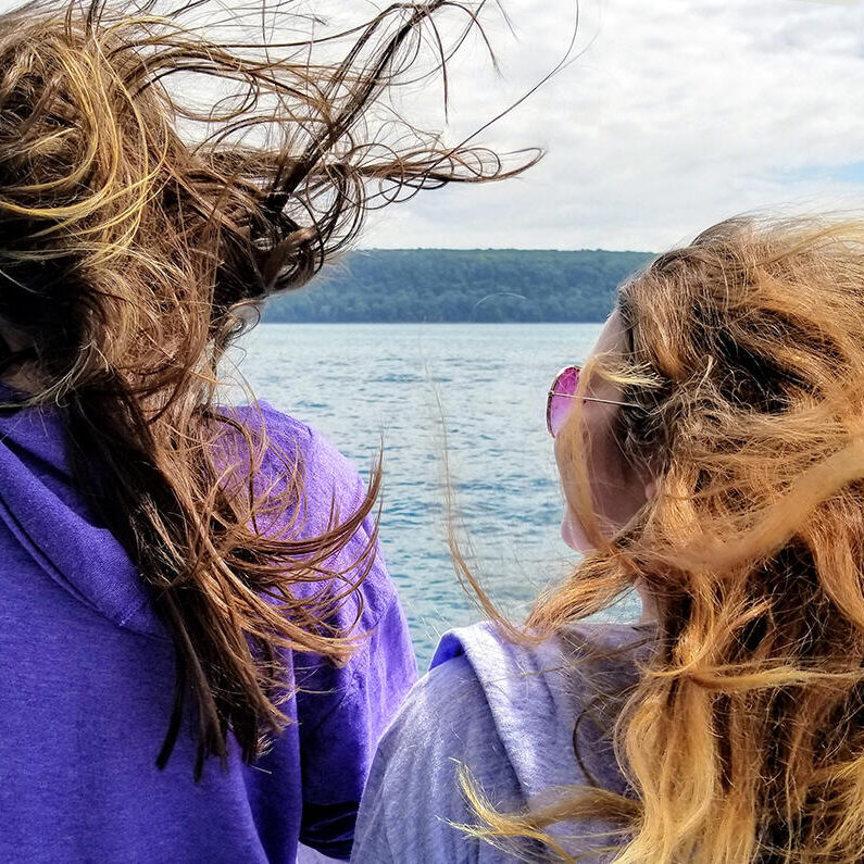 Enjoying a windy boat tour of Pictured Rocks National Lakeshore on Lake Superior in Munising, Michigan - Upper Peninsula - 2 women with wild windblown hair